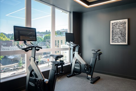 two exercise bikes in a gym next to a window